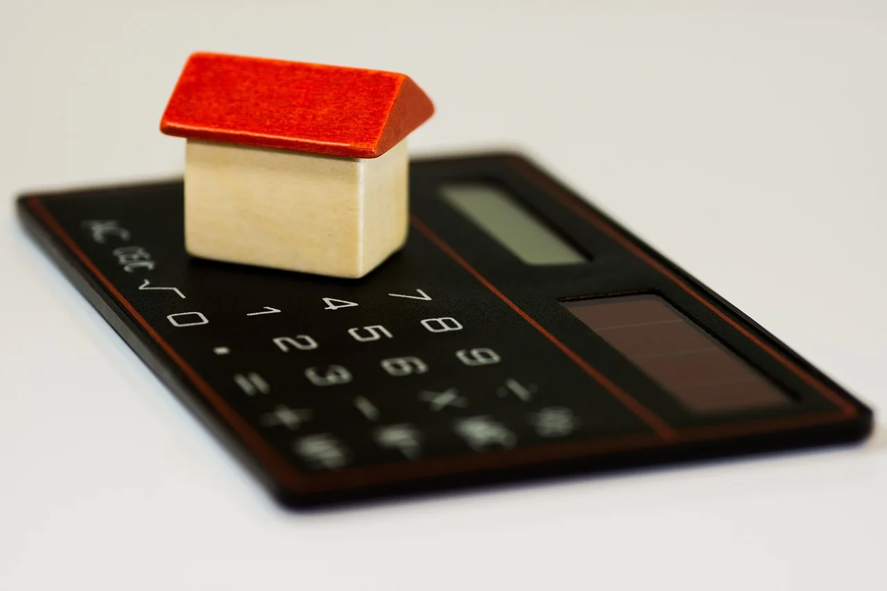 Calculator on a desk with coins and a chart showing customer acquisition cost