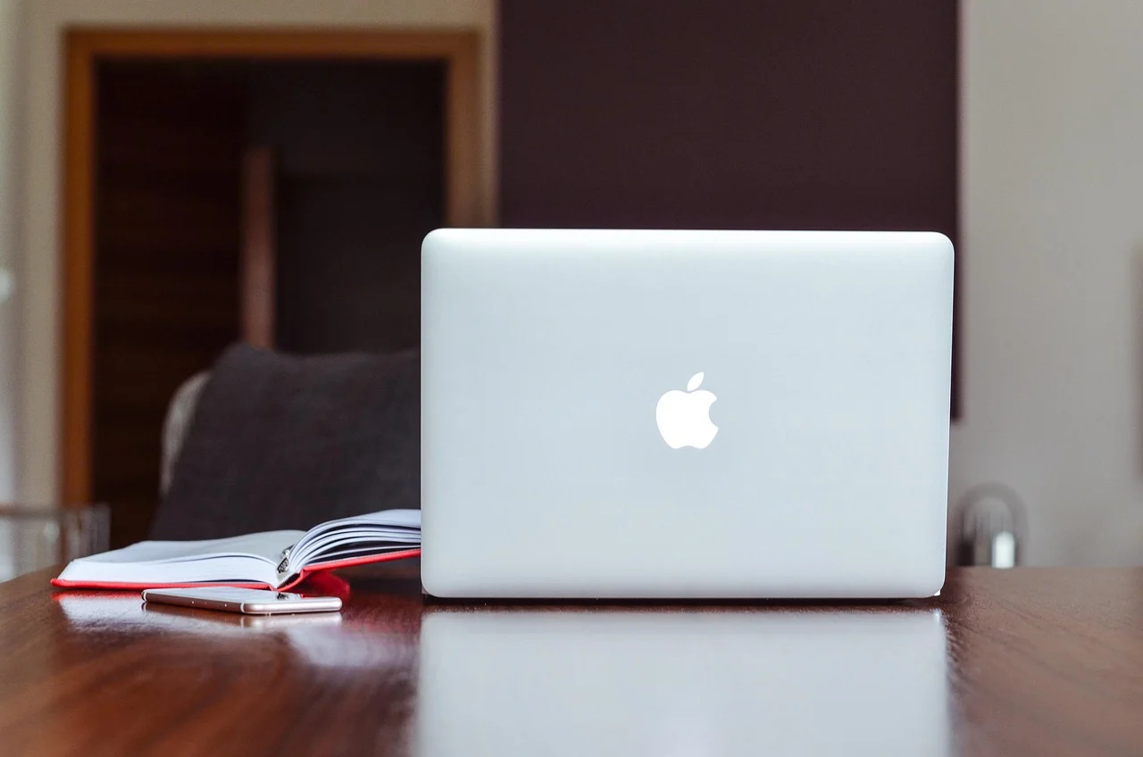 Laptop on a desk with a cup of coffee and a notepad, representing B2B PPC work